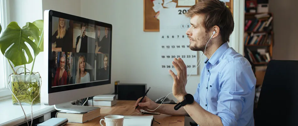 A man in a virtual meeting on a computer with other people